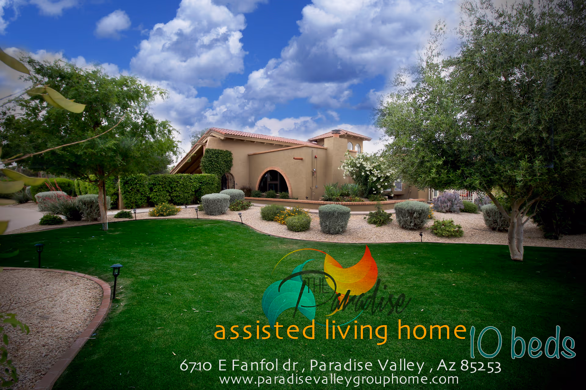 Exterior view of The Paradise Assisted Living Home showing a single-story building with a tiled roof surrounded by well-maintained landscaping including green grass, bushes, trees, and a clear blue sky with clouds.