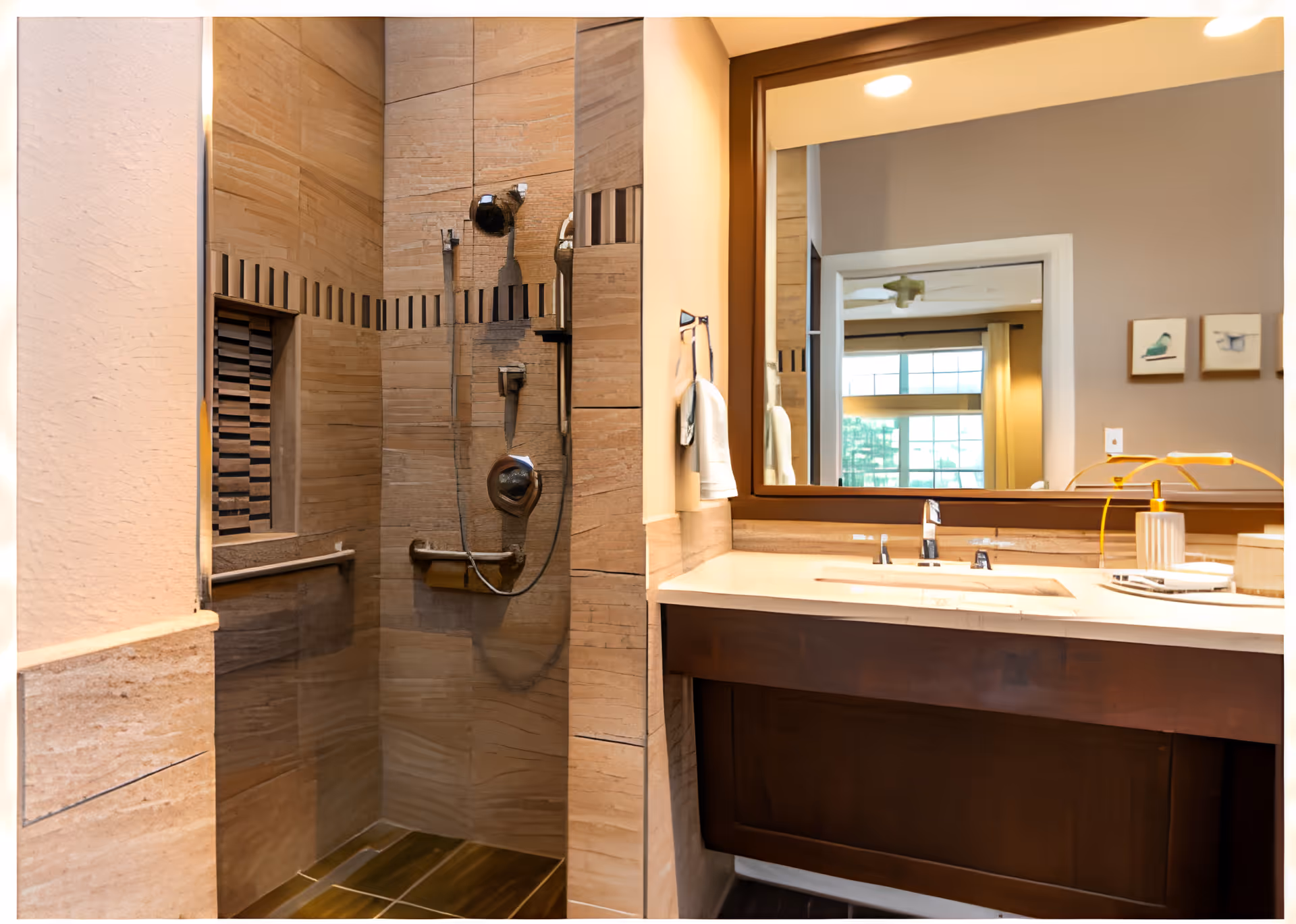 Tiled bathroom featuring a walk-in shower with handheld showerhead and grab bar, and a vanity with sink and large mirror.