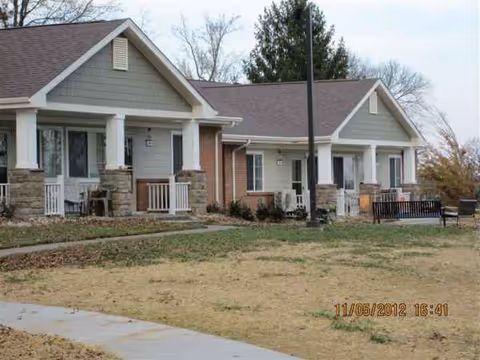 Exterior view of Greensburg Village senior living facility with front porches and lawn.