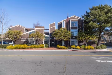 Front view of San Rafael Commons senior living facility with a landscaped entrance.
