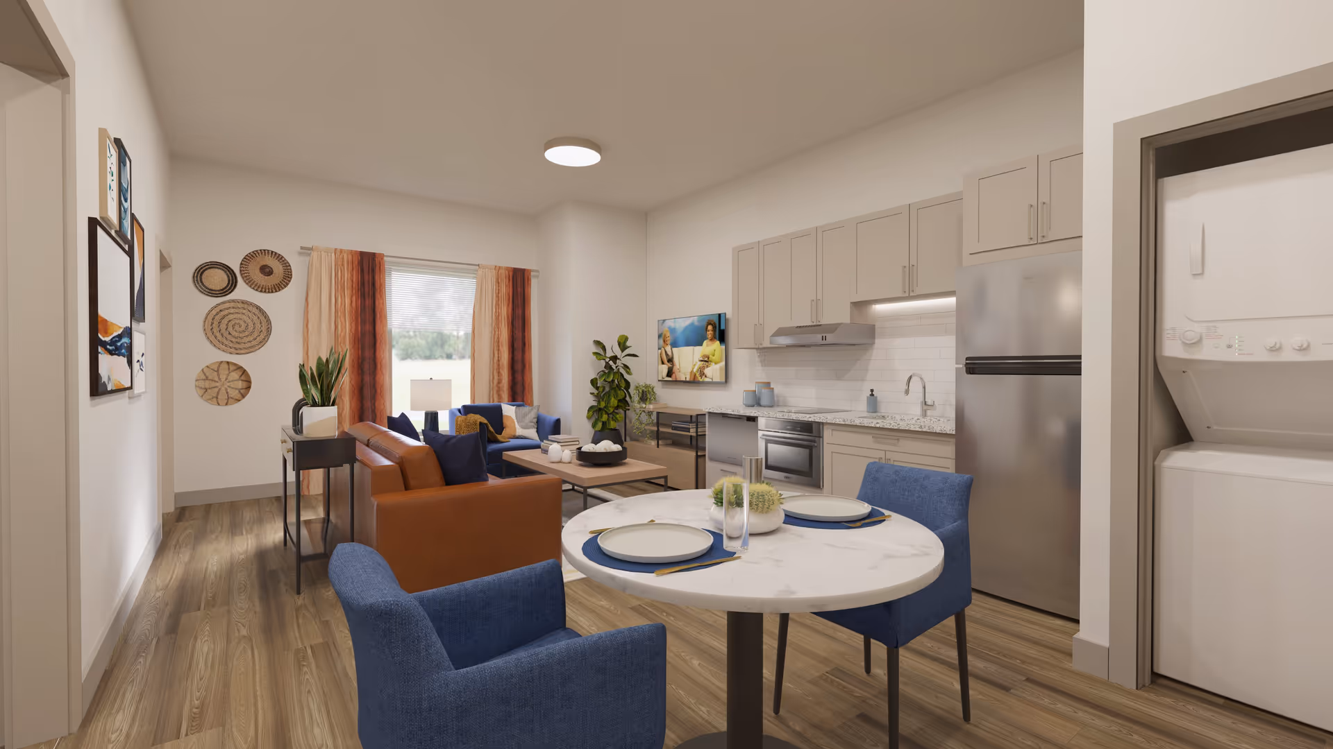 Open-plan living room and kitchen with a round dining table and blue chairs, a brown leather sofa, wall-mounted TV, and a stacked washer/dryer.