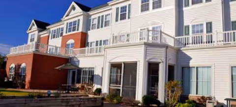 Exterior view of Saddlebrook Senior Living building with balconies and a courtyard.