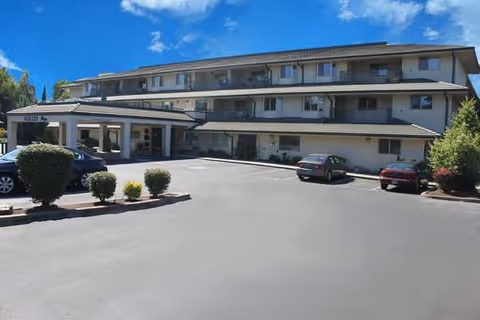 Three-story Horton Plaza senior living facility exterior with parking lot and entrance.
