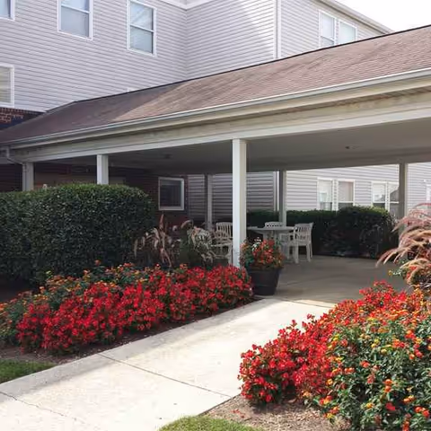 Exterior view of Lexington Commons showing a covered patio with tables and flowers.