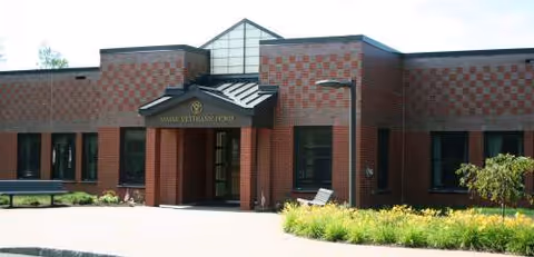 Brick exterior of Maine Veterans' Home Bangor with entrance canopy and landscaping.