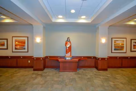 Central statue on pedestal in a spacious interior lobby with framed art.