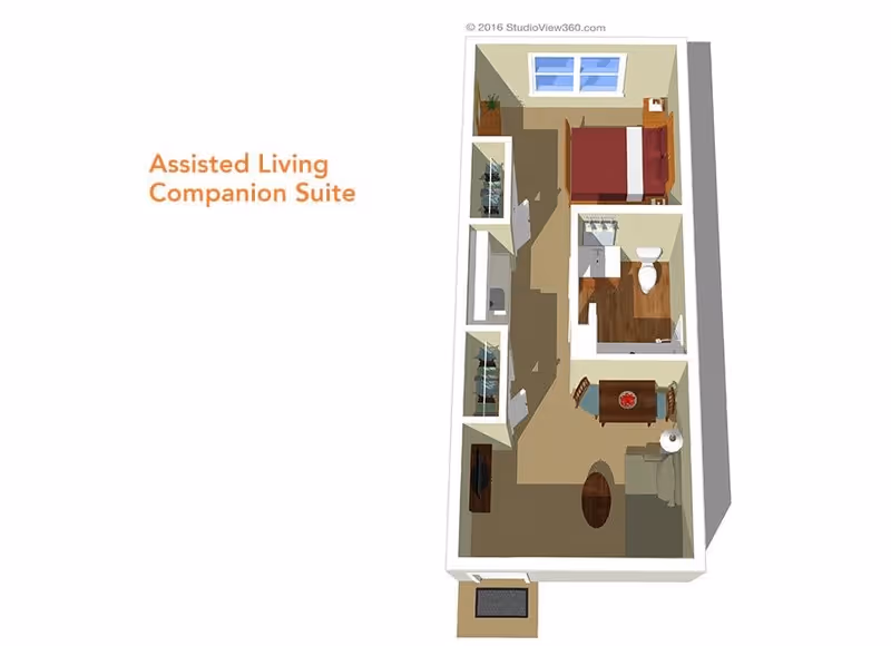 3D floor plan of an assisted living companion suite showing a bedroom with a bed and nightstand, a bathroom with a toilet and sink, a dining area with a table and two chairs, and a living area with a sofa, coffee table, and TV. The layout includes closets and a small entryway.