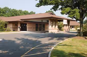 Exterior view of a senior living facility with a covered entrance and curved driveway.