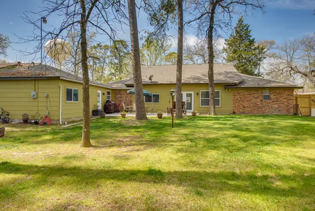 Exterior view of The Pines at Oakhurst with a green lawn and trees.