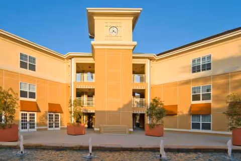 Sunlit exterior of Atherton Baptist Homes showing a central tower and courtyard.