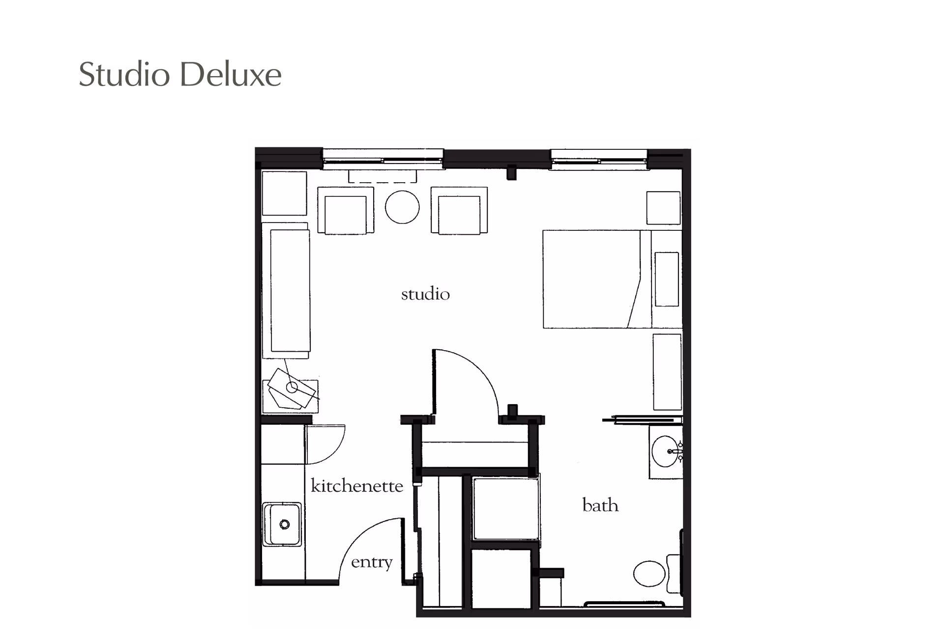 Floor plan of a Studio Deluxe apartment at Atria Grapevine showing a studio living area with seating and a bed, a kitchenette near the entry, and a bathroom with a sink and toilet.