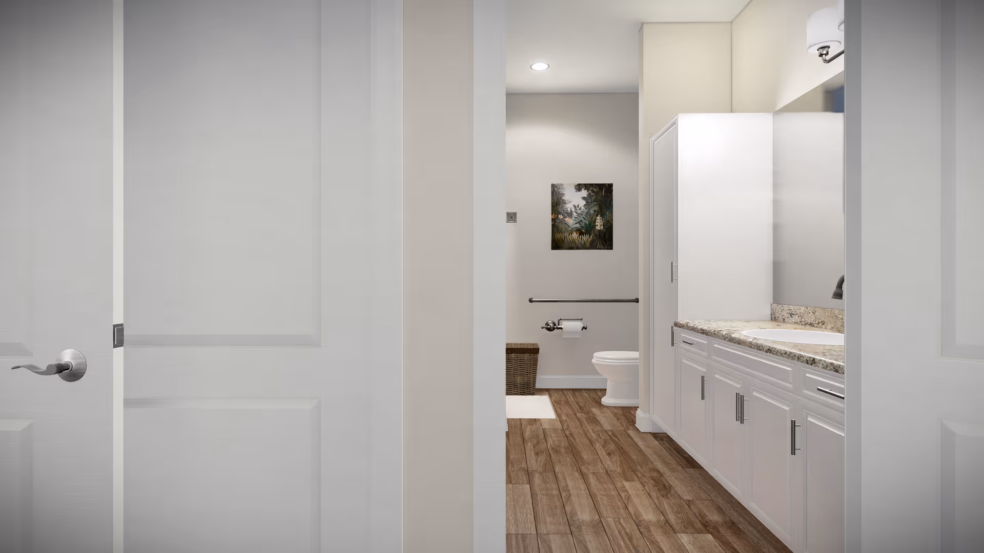 View into a clean, modern bathroom with wood-look flooring, white cabinetry with granite countertop and sink on the right, a toilet with a grab bar and a wicker basket in the back, and a nature-themed framed picture on the wall.