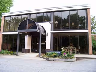 Front view of a glass front senior living facility entrance.