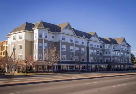 Exterior view of a Sunrise at Cherry Creek senior living building along a street.