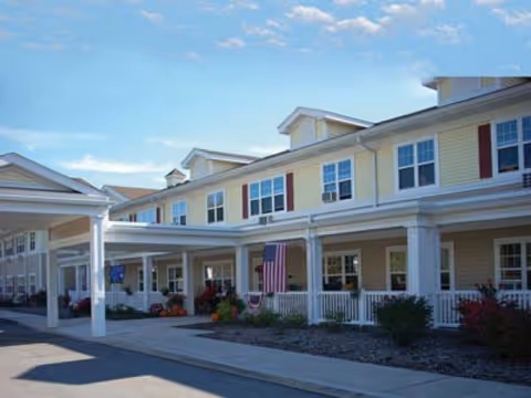 The Northfield senior living facility front exterior with porch and flag.
