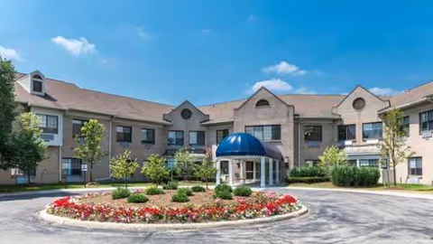 Exterior view of SKLD West Bloomfield building with circular driveway and landscaped flower bed.