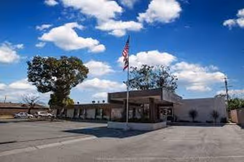 Front exterior view of Sierra View Care Center with entrance, flagpole, and parking lot.