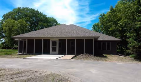 A single-story building with a covered front porch and ramp.