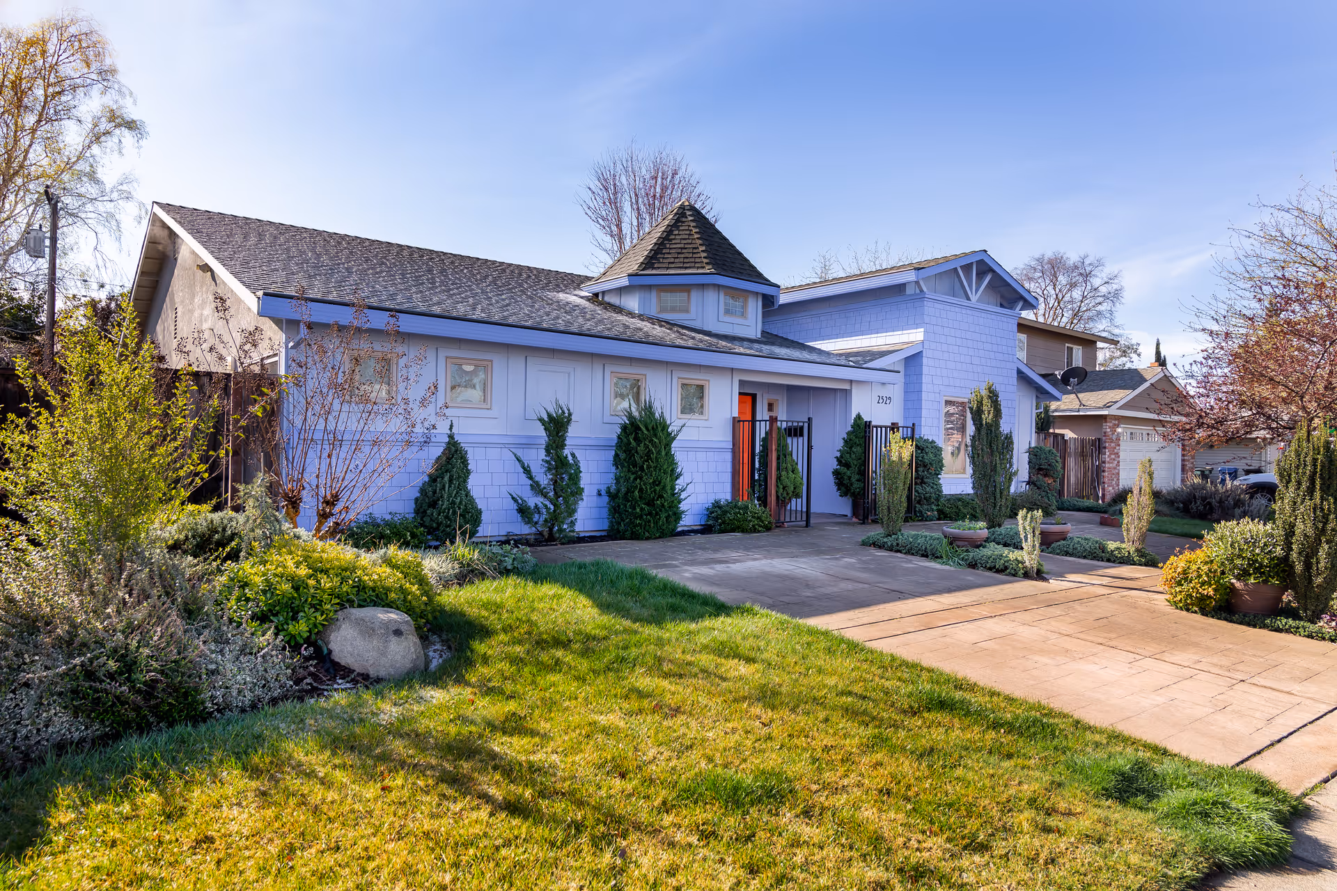 Blue single-story senior living facility with landscaped front yard and a wide driveway.