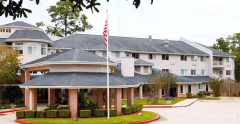 Exterior view of University Pines Sky Active Living facility with flagpole.