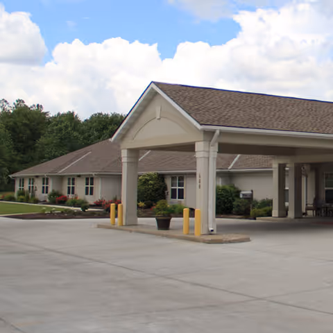 Covered entrance/porte-cochere of Vintage Park at Hiawatha with a single-story building, driveway, and landscaped grounds.
