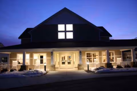 Evening exterior of Medilodge of Montrose with a lit entryway and front porch.