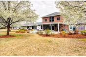 Exterior view of Branchwater Village LLC facility with brick building, trees, and a sidewalk.