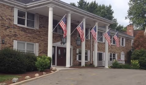 Kenosha Estates Rehab and Care Center exterior with flag-lined entrance and columns.