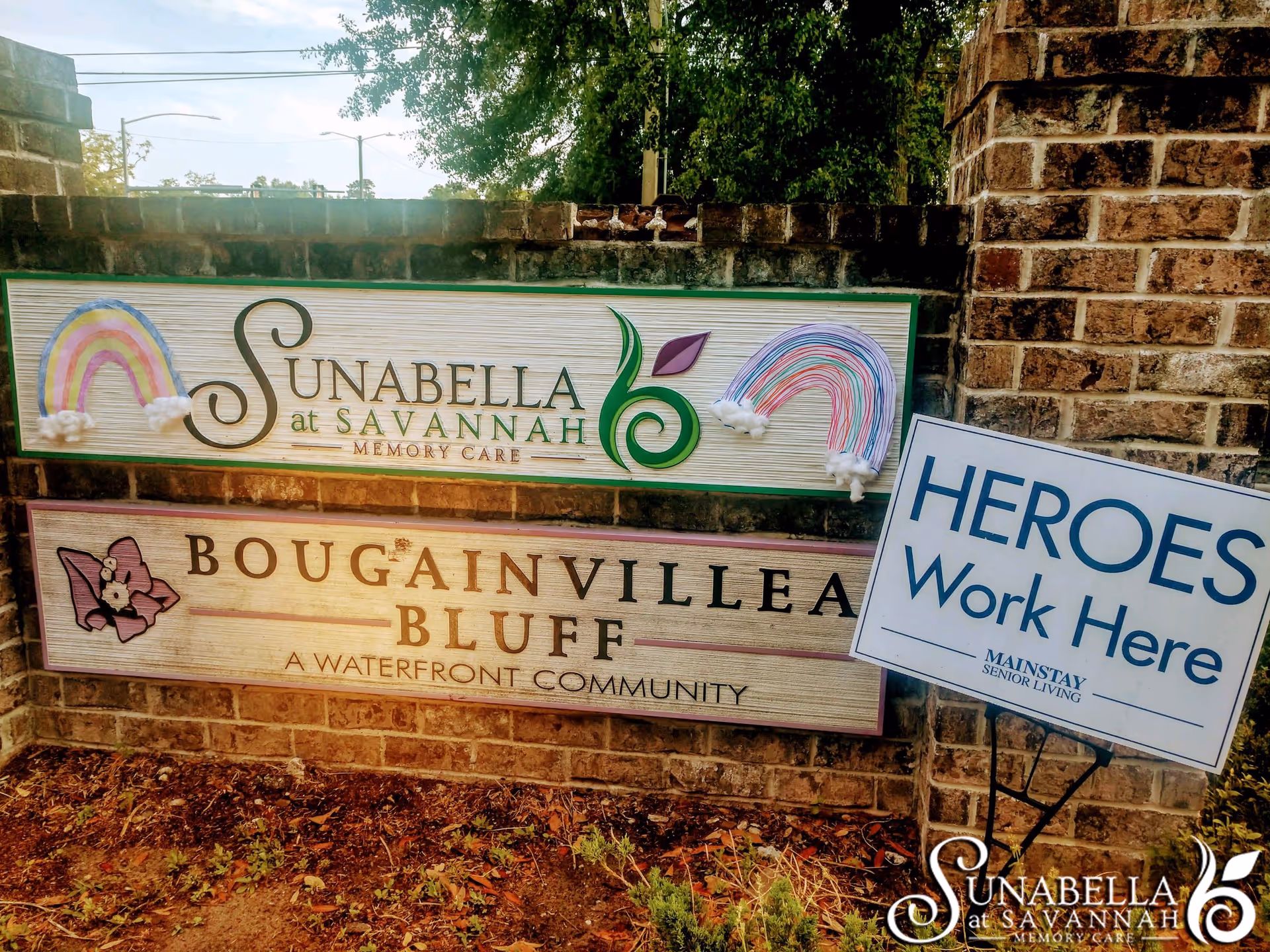 Brick entrance sign for Sunabella at Savannah and Bougainvillea Bluff with a nearby 'Heroes Work Here' yard sign.