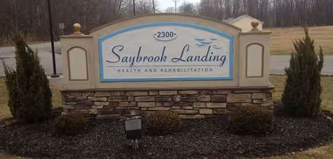 Saybrook Landing Health and Rehabilitation sign atop a stone base in front of landscaped grounds.