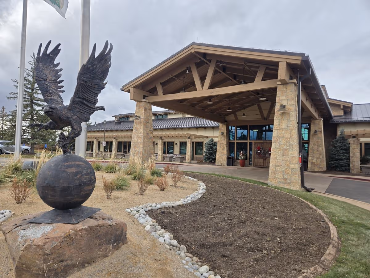Entrance of Heritage at Eagle Bend Golf Club featuring a covered porte-cochere and a large eagle statue in the foreground.