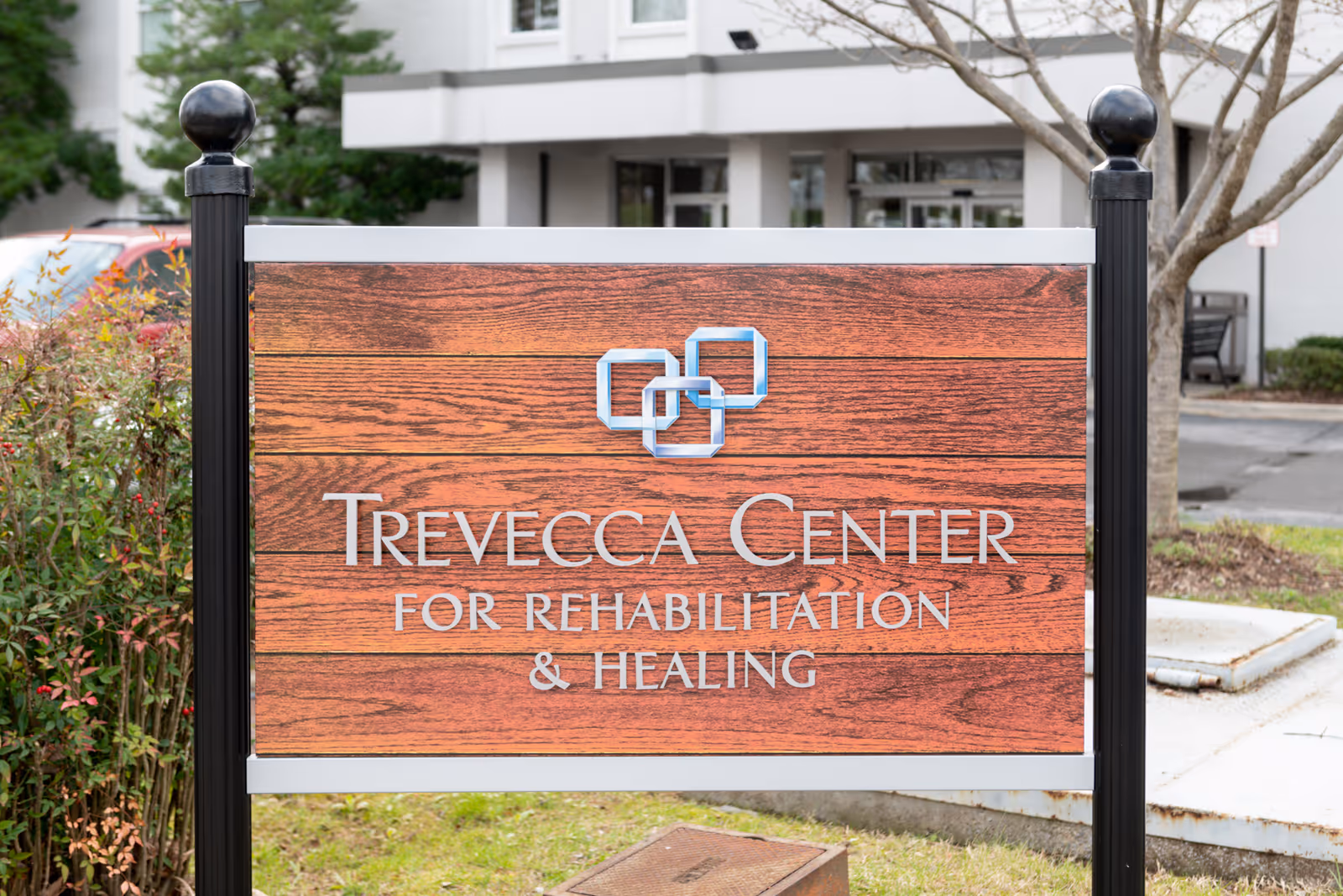 A wooden sign in front of a facility entrance reads "Trevecca Center for Rehabilitation & Healing".