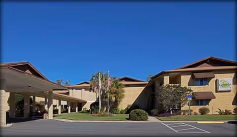 Exterior view of Camelot Chateau Assisted Living with entrance drive and manicured landscaping.