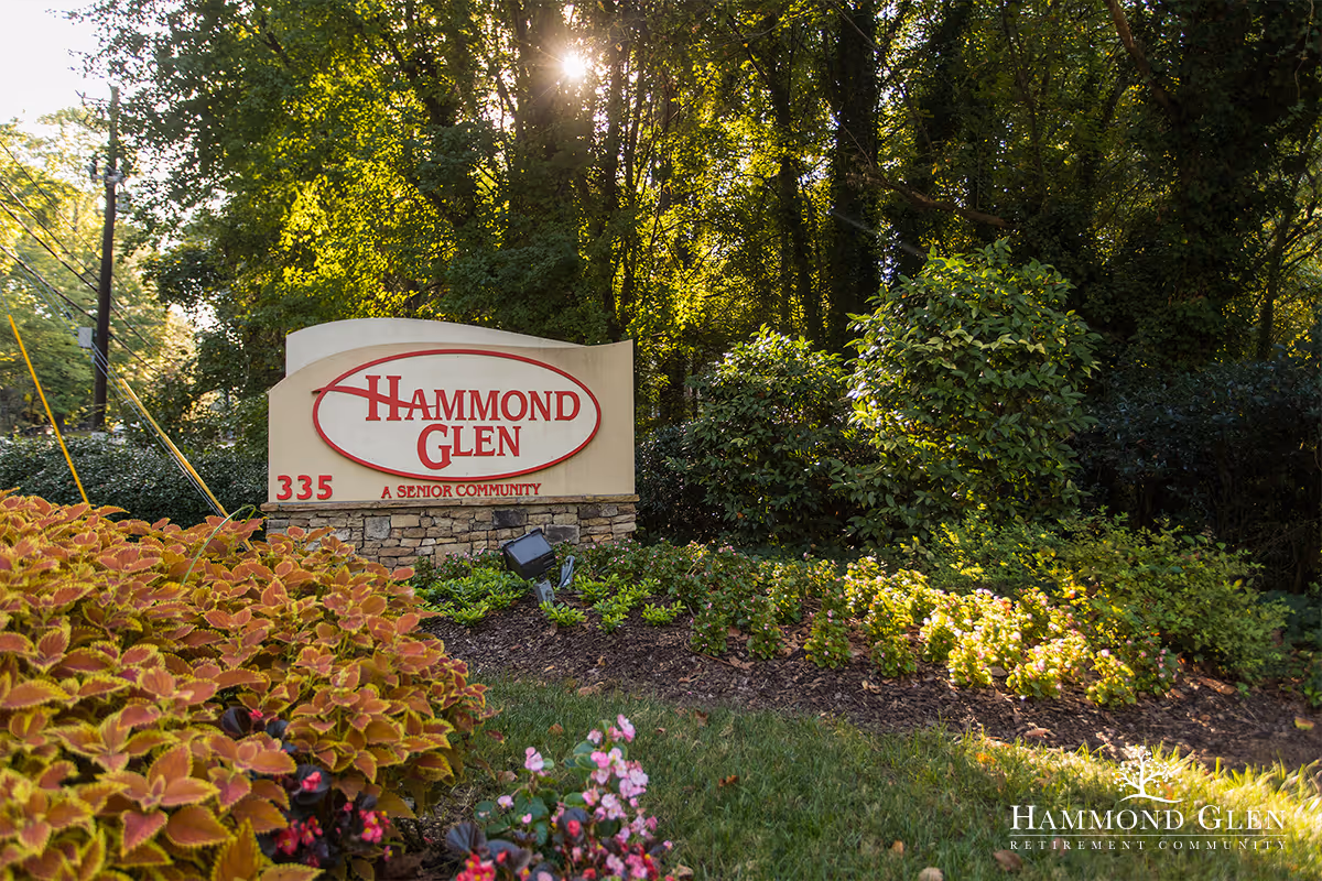Entrance sign for Hammond Glen Retirement Community surrounded by landscaped shrubs and trees.