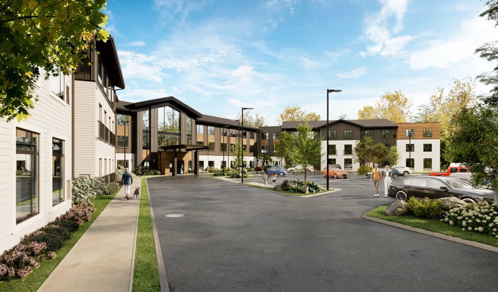 Exterior view of a modern three-story assisted living facility with a parking lot in front. Several people are walking on the sidewalks and near the entrance, surrounded by trees and landscaped greenery under a partly cloudy sky.