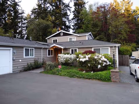 Front exterior view of Hillwood Senior Care building with driveway and landscaping.