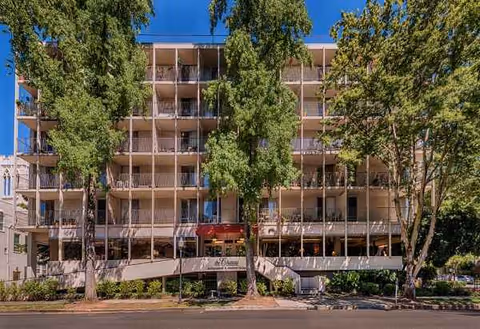 Exterior view of The Chateau on Capitol Avenue building with balconies and surrounding trees