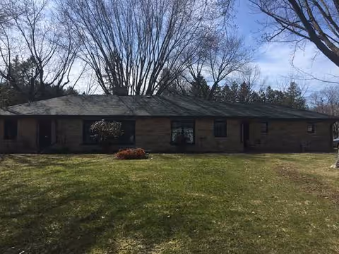 Exterior view of a single-story brick building with a green lawn.