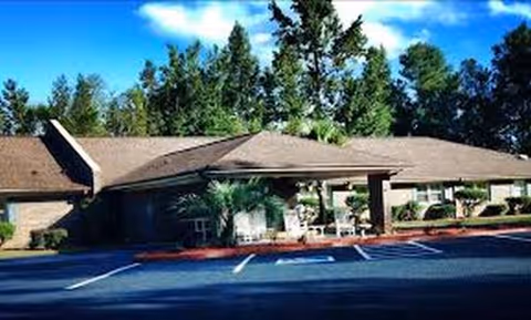 Exterior view of a single-story senior living facility with a covered entrance.