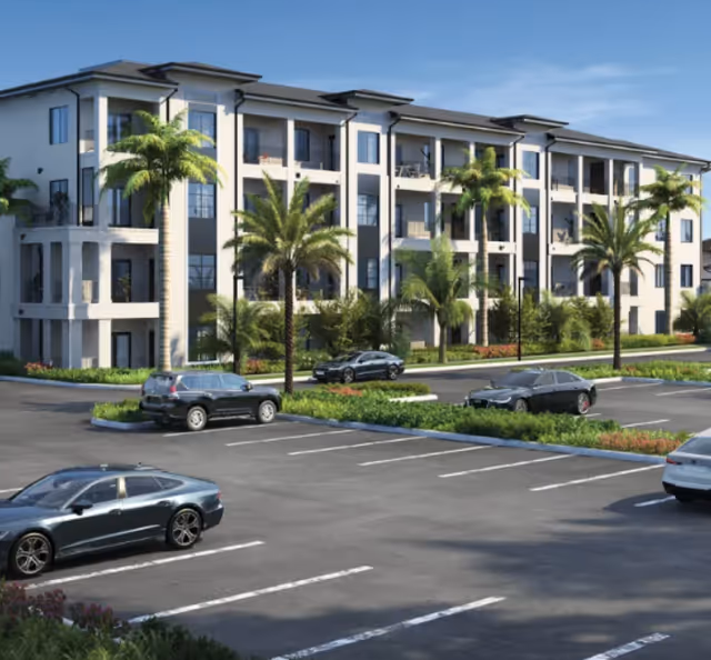 Exterior view of a multi-story senior living building with palm trees and parking.