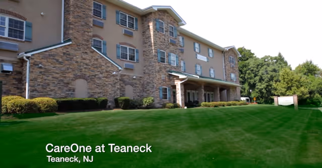 Exterior view of CareOne at Teaneck building with green lawn and entryway.