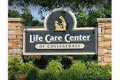 Front sign reads Life Care Center of Collegedale with brick pillars and manicured greenery.