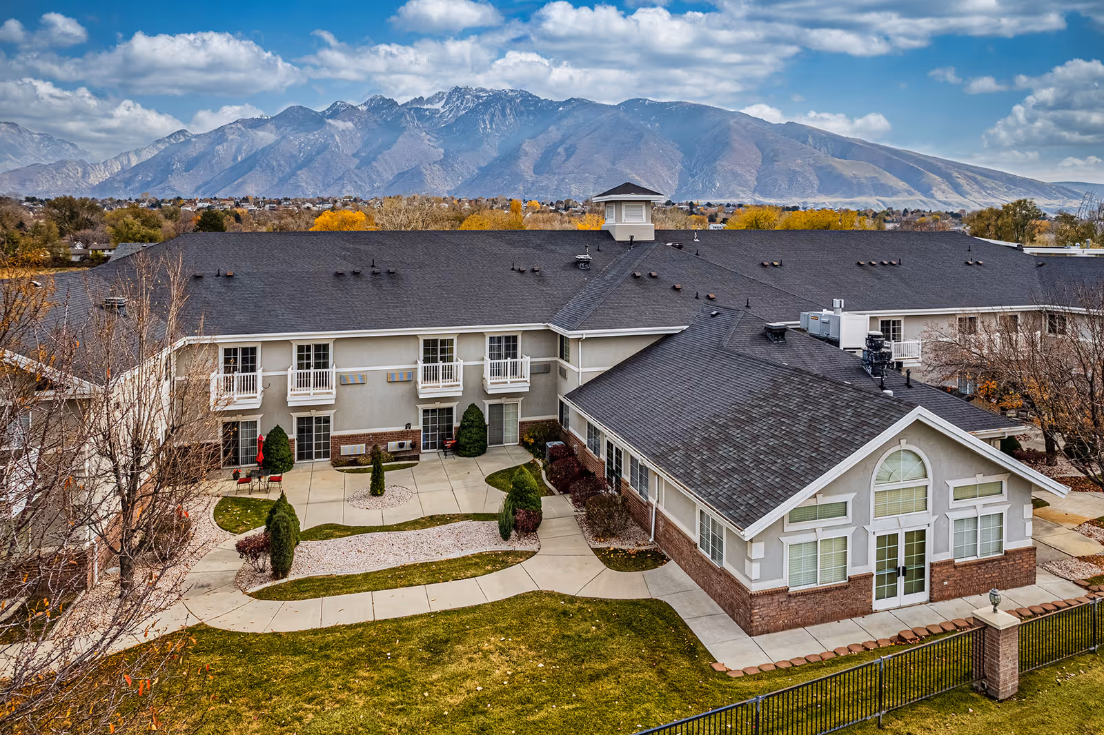 Aerial exterior view of the Valencia at Draper senior living facility with a landscaped courtyard and mountains in the background.