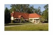 Single-story retirement community building with red tile roof and manicured lawn.