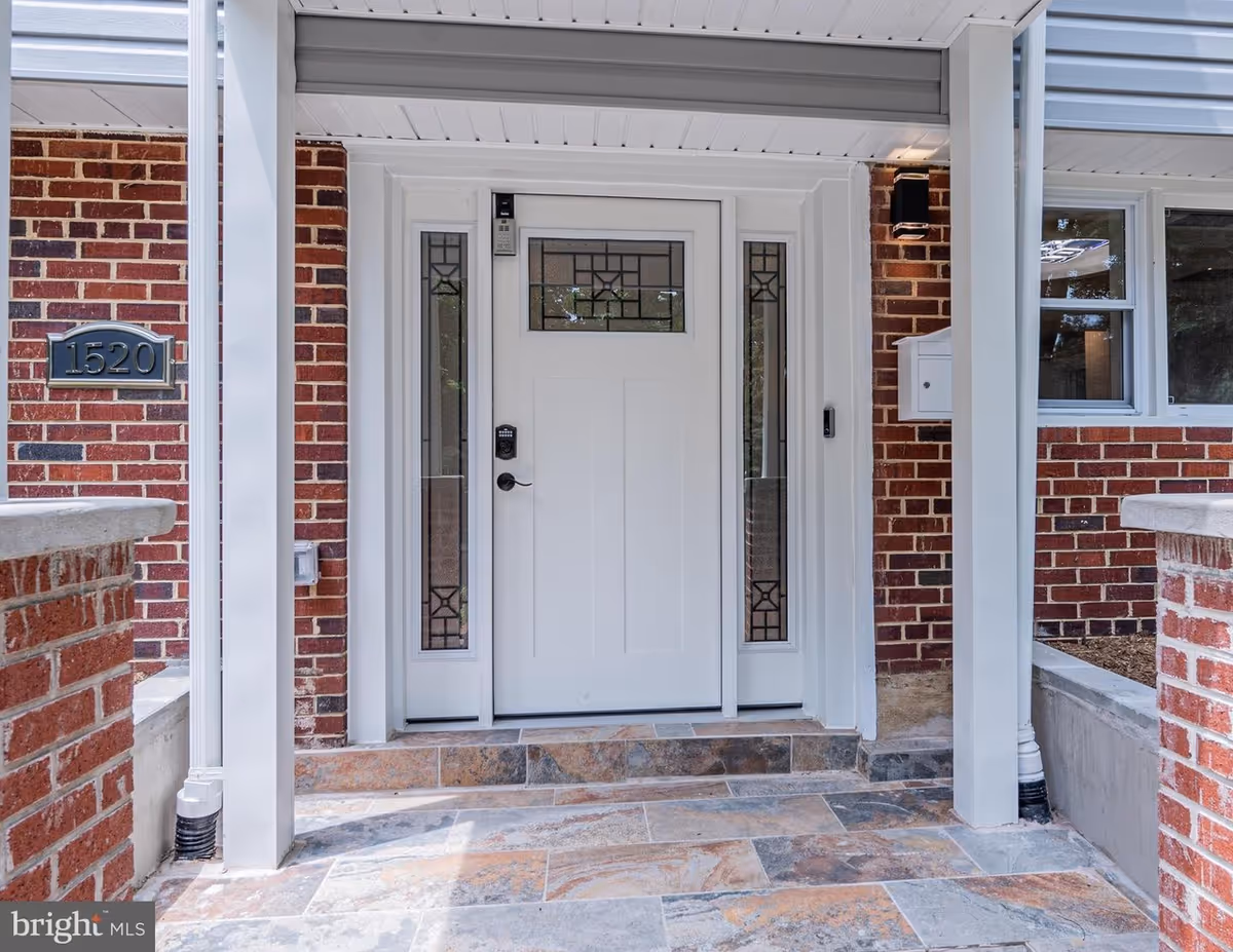 Entrance of a senior living facility featuring a white door and brick exterior.