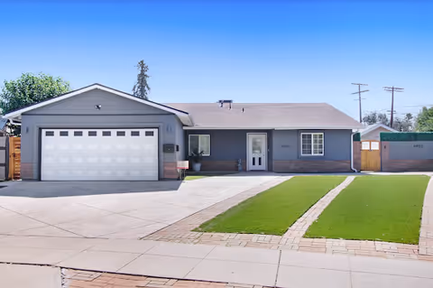 Single-story gray retirement residence with a two-car garage and manicured lawn.