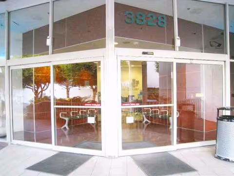 Double glass doors at a building entrance with seating visible inside.
