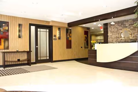 Lobby reception area with curved desk, wood panel walls, and doorway.