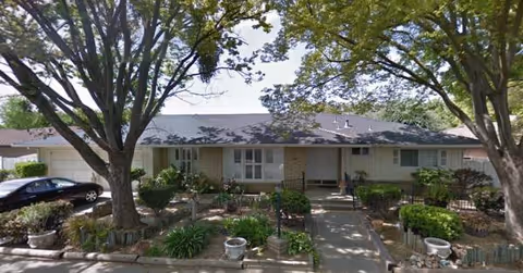 Front view of Parkview Village II with trees, shrubs, and a landscaped walkway to the entrance.