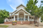 Front view of Bradford Village senior living facility with a covered porch, white railings, and brick base.